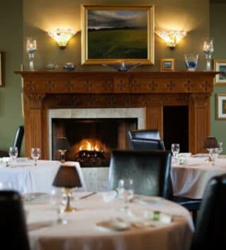 formal dining tables set in front of a large fireplace