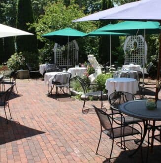 round bistro tables on a patio with colorful umbrellas